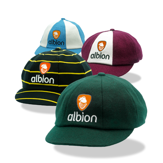 Four Albion baggy caps in different colourways: dark green, black with yellow stripes, burgundy and white, and light blue and white, each featuring the orange Albion logo embroidered on the front.