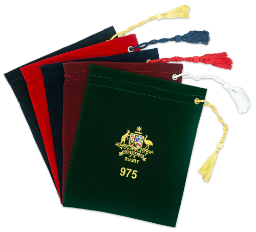 Five presentation cap bags in different colours: dark green, burgundy, dark navy, red and black. Each has a tassel and embroidered logo.
