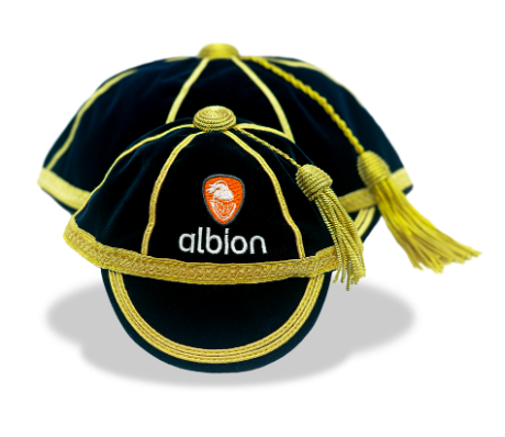Two dark navy honours caps with gold trim and tassels. One honours cap is a mini cap and is in front of the regular sized honours cap.
