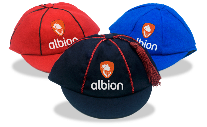 Three Albion varsity caps in different colours: dark navy, red, and royal blue, each featuring the orange Albion logo embroidered on the front.