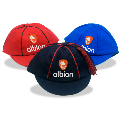 Three Albion varsity caps in different colours: dark navy, red, and royal blue, each featuring the orange Albion logo embroidered on the front.